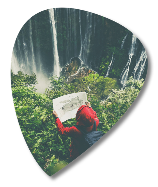 An explorer reading a map before a waterfall