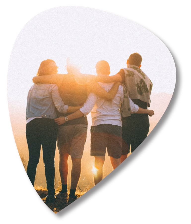 Four friends arm in arm watching the sunset